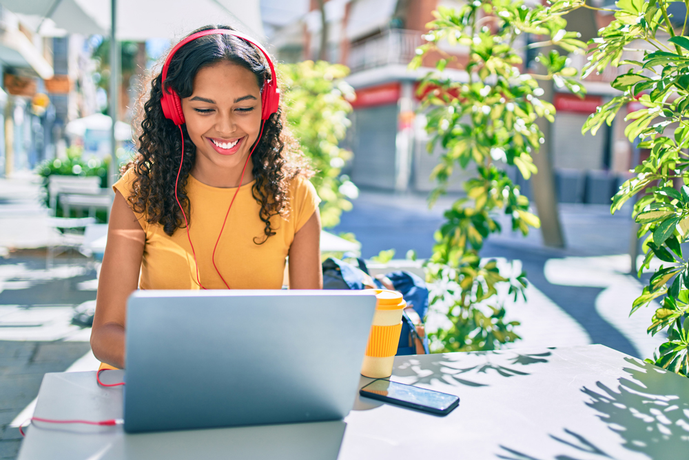 Woman working on laptop in backyard