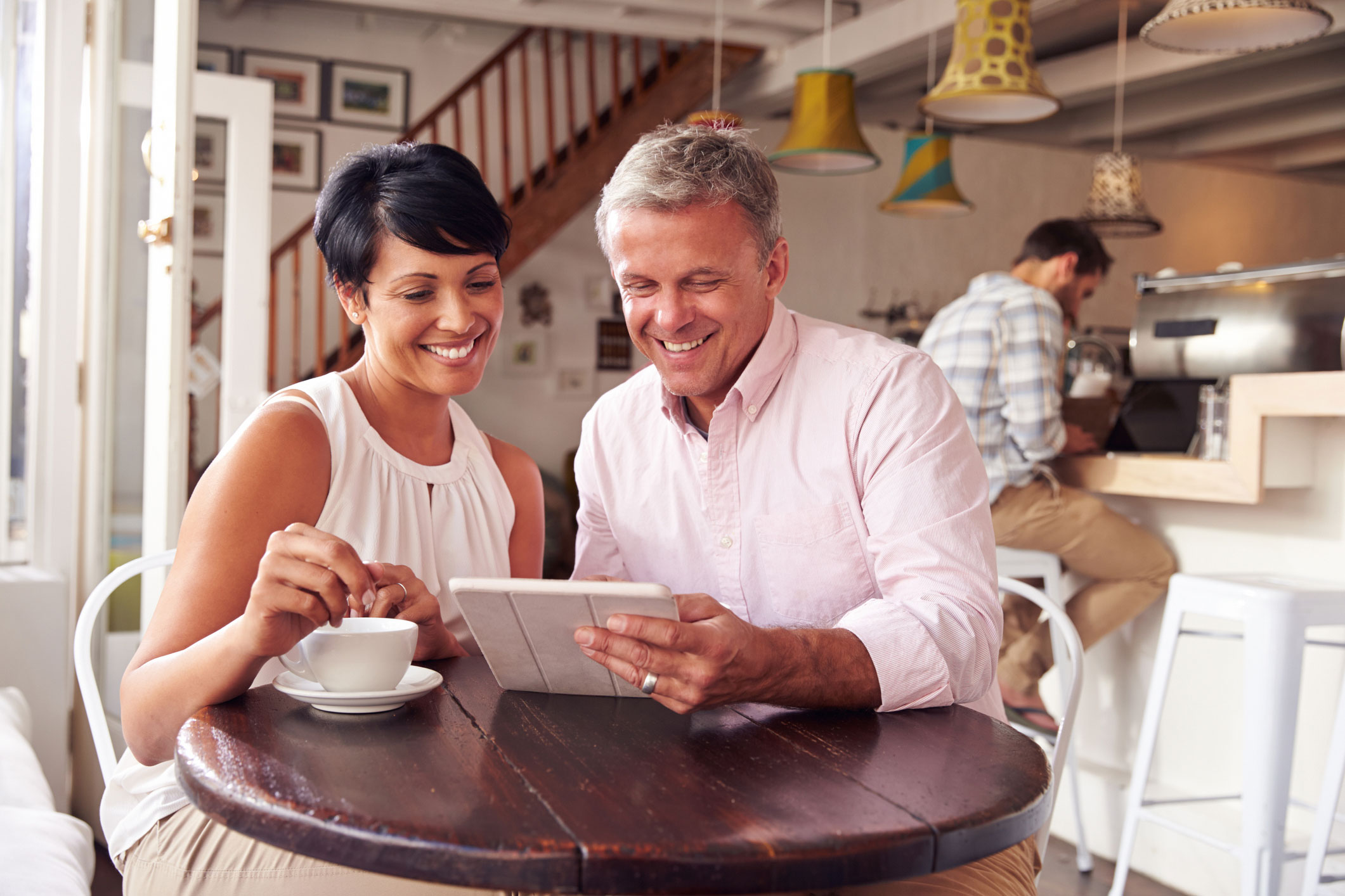 Couple viewing tablet at the dinner table.