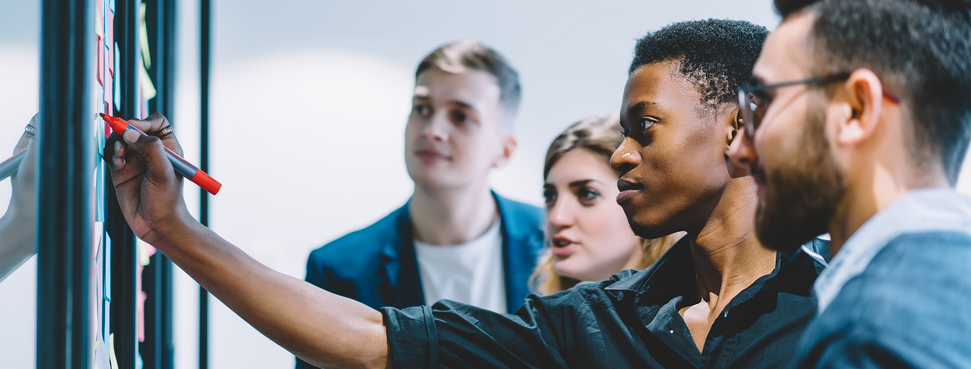 A focused group of colleagues work on a white board together